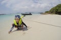 Happy asian girl wear life jacket,mask and snorkel,enjoy playing sand on the beach,tourist attractions at Koh Samaesarn,Chon Buri,