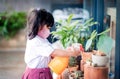 Happy Asian Girl wearing a Surgical Protection Mask while Enjoying in Garden at School or Home, a Child in Student Uniform Royalty Free Stock Photo