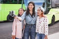 Happy asian girls making video at city bus station - Content creators friends vlogging for social network outdoor - Technology,