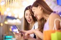 Happy girls watching phone in the shopping mall Royalty Free Stock Photo