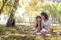 Happy Asian grandmother picnicking with her lovely granddaughter in park together. leisure and family concept Royalty Free Stock Photo