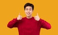 Happy asian guy gesturing thumbs up and smiling Royalty Free Stock Photo