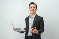 happy asian indonesian business man in suit holding smart phone and laptop computer on isolated background Royalty Free Stock Photo