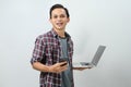 Happy asian indonesian man holding smartphone and laptop computer on isolated background Royalty Free Stock Photo