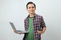 Happy asian indonesian man holding smartphone and laptop computer on isolated background Royalty Free Stock Photo