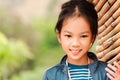 Happy Kid girl looking at camera with smile while playing in public park wooden bamboo playground Royalty Free Stock Photo