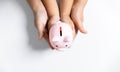 Happy Asian kid and mom saving money together, putting cash into piggy bank. Mother playing with child on heating floor at home, Royalty Free Stock Photo