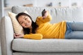 Happy asian kid laying on couch, watching TV Royalty Free Stock Photo