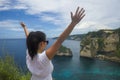 Happy Asian Korean woman in sunglasses enjoying amazing coast scene from view point at tropical paradise beach with diamond rock Royalty Free Stock Photo