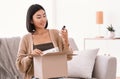 Happy asian lady unpacking parcel with beauty box Royalty Free Stock Photo