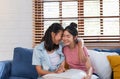 Happy asian lesbian couple hug each other with love on sofa at living room at home,LGBTQ lifestyle concept