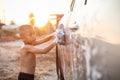 Happy asian little boy playing white soap and using blue sponge to washing the car at outdoor in sunset time Royalty Free Stock Photo