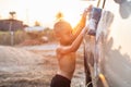 Happy asian little boy playing white soap and using blue sponge to washing the car at outdoor in sunset time Royalty Free Stock Photo