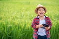 Happy Asian Little boy with a tablet interested in learning the surroundings in the green fields, education concept outside the