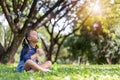 Asian little child girl blowing soap bubbles outside in green park Royalty Free Stock Photo