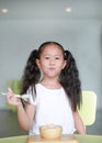 Happy Asian little child girl eating healthy food with deliciousness at home Royalty Free Stock Photo