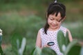 Happy asian little child girl looking through a magnifying glass on green leaf tree in the park Royalty Free Stock Photo