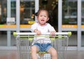 Happy Asian little child girl sitting in the trolley during family shopping in the market Royalty Free Stock Photo