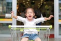 Happy Asian little child girl sitting in the trolley during family shopping in the market Royalty Free Stock Photo