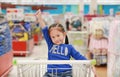 Happy Asian little child girl sitting in the trolley during family shopping in the market Royalty Free Stock Photo