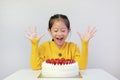 Happy asian little child girl with strawberry cake isolated on white. Kid with happy birthday cake on the table Royalty Free Stock Photo