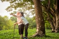 Happy asian little child girl support,hug senior grandmother,smiling granddaughter in outdoor park,elderly woman with walking