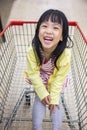 Happy Asian Little Chinese Girl sitting in shopping cart Royalty Free Stock Photo