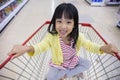 Happy Asian Little Chinese Girl sitting in shopping cart Royalty Free Stock Photo