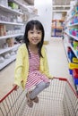 Happy Asian Little Chinese Girl sitting in shopping cart Royalty Free Stock Photo