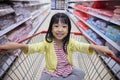 Happy Asian Little Chinese Girl sitting in shopping cart Royalty Free Stock Photo