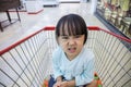 Happy Asian Little Chinese Girl sitting in shopping cart Royalty Free Stock Photo