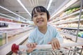 Happy Asian Little Chinese Girl sitting in shopping cart Royalty Free Stock Photo