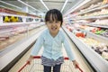 Happy Asian Little Chinese Girl sitting in shopping cart Royalty Free Stock Photo