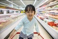 Happy Asian Little Chinese Girl sitting in shopping cart Royalty Free Stock Photo