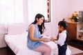 Happy asian little daughter with mother holding gift box together at home