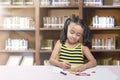 Happy asian little girl drawing on paper with crayon Royalty Free Stock Photo