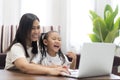 Happy asian little girl with mother using laptop computer, Royalty Free Stock Photo