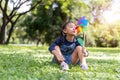 Asian little girl playing with paper windmill in the garden Royalty Free Stock Photo