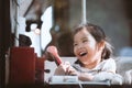 Happy asian little girl playing and talking phone in cafe Royalty Free Stock Photo