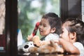 Happy asian little girl playing and talking phone in cafe Royalty Free Stock Photo