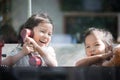 Happy asian little girl playing and talking phone in cafe Royalty Free Stock Photo