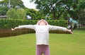 Happy Asian little girl relax open arms wide in the garden Royalty Free Stock Photo