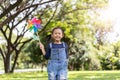 Asian little girl running in park playing with paper windmill Royalty Free Stock Photo