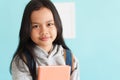 Happy Asian little girl smile on the face, Asia child hold book and backpack while standing in interior home. Portrait of a kid Royalty Free Stock Photo