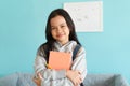 Happy Asian little girl smile on the face, Asia child hold book and backpack while standing in interior home. Portrait of a kid Royalty Free Stock Photo