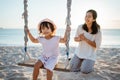 happy Little girl and mother swinging at the beach Royalty Free Stock Photo