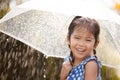 Happy asian little girl with umbrella in rain Royalty Free Stock Photo