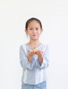 Happy asian little kid girl hold and eating Custard Cake isolated over white background