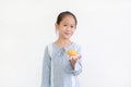 Happy asian little kid girl hold and eating Custard Cake over white background