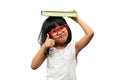 Happy Asian little preschool girl wearing red glasses holding a green book and thumbs up on white isolated background. Concept of Royalty Free Stock Photo